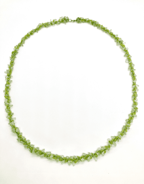 A delicate green beaded necklace with a twisted design.