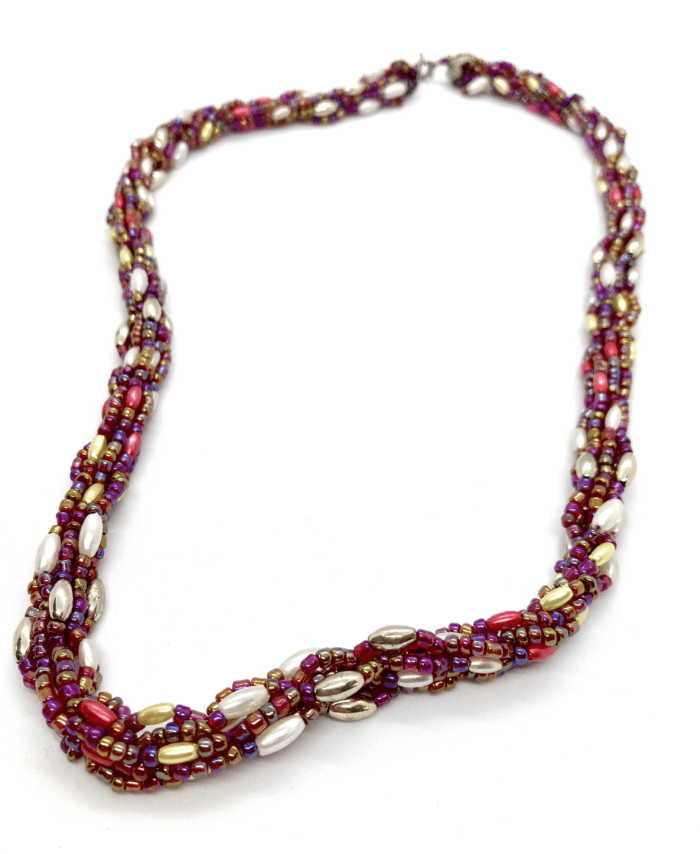 A vibrant pink and gold beaded necklace with a twisted design.