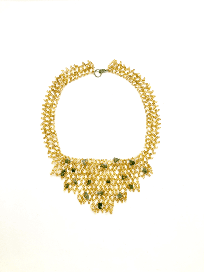 Gold beaded necklace with green accents. The necklace has a cascading design and features a mix of small, round beads and larger, irregularly shaped beads.