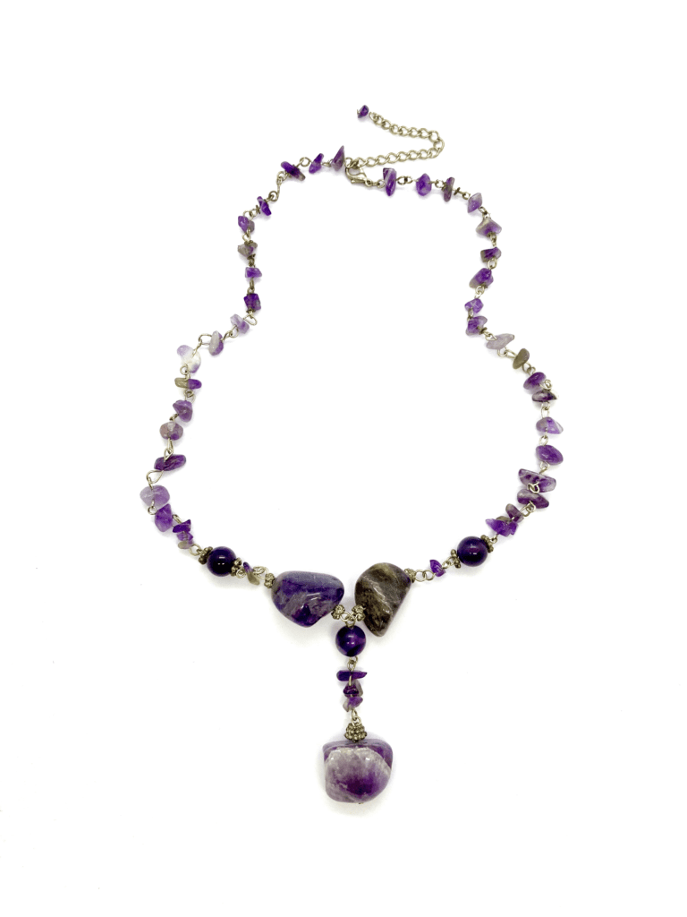  A multi-strand beaded necklace featuring amethyst stones in various sizes and shapes, with a larger amethyst pendant at the center.