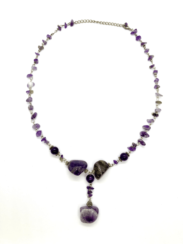 A vintage-inspired amethyst necklace with a mix of small and large amethyst beads, and a brass-colored clasp