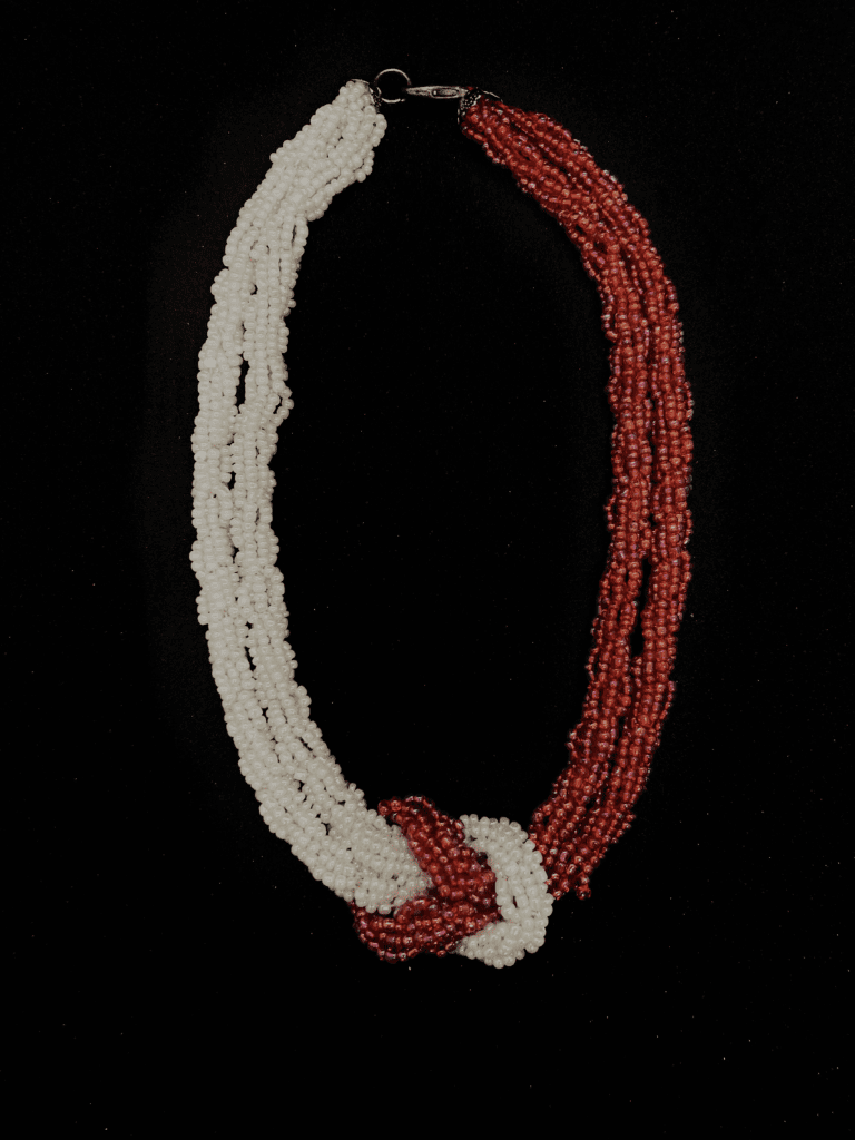 A statement necklace made of white and red beads, perfect for adding a touch of drama to any outfit.