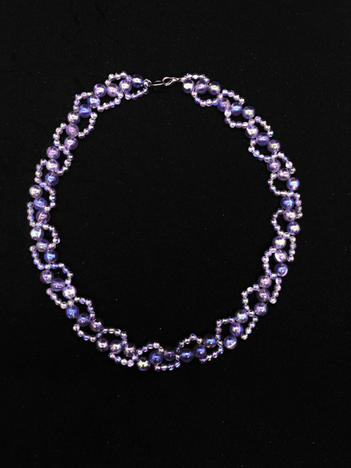 A unique beaded necklace with a mix of purple and iridescent hues, creating a mesmerizing effect.