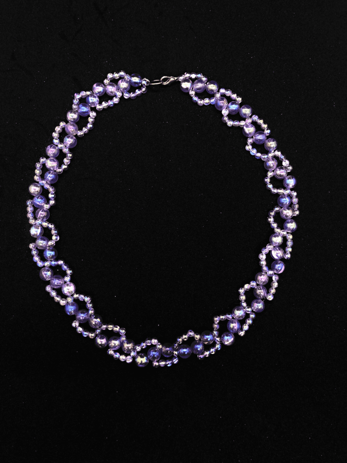 A unique beaded necklace with a mix of purple and iridescent hues, creating a mesmerizing effect.