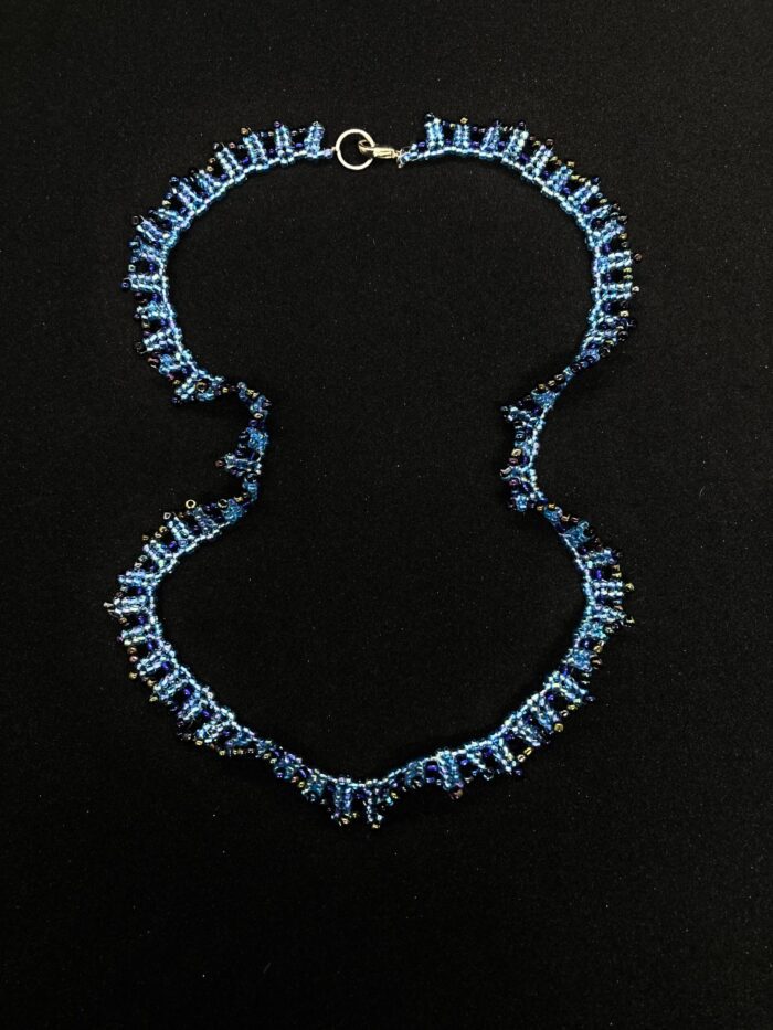 A unique beaded necklace inspired by the ocean, with shimmering blue and purple beads.