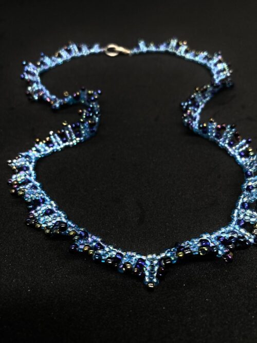 A beaded necklace with a cascading design, featuring shades of blue and purple.