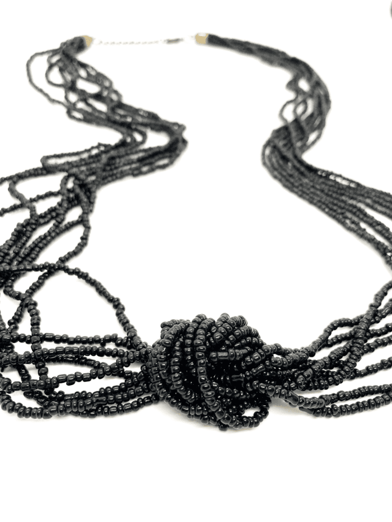  A long black beaded necklace with multiple strands and a clasp closure.