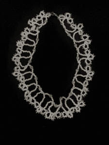 A delicate white beaded necklace with a lace-like pattern