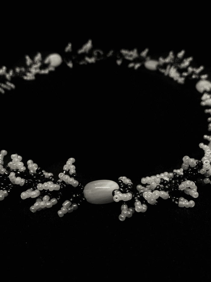 Black and white beaded necklace with a unique, swirling design.