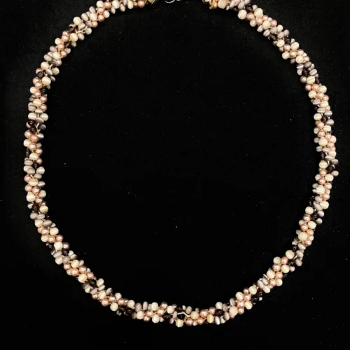 Circular Kumihimo necklace featuring peach pearls and cream beads with gold clasp